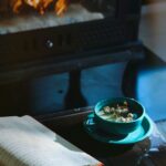 Open journal and herbal tea near a cozy fireplace, symbolizing relaxation, mindfulness, and introspection